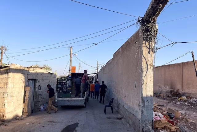 عمال وسكان يساعدون السكان في إخلاء منازلهم في حي السومرية بدمشق في 29 آب/ أغسطس الفائت - رويترز