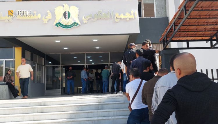 توافد أشخاص ممن يحملون بطاقات تسوية إلى قسم الشرطة بالمجمع الحكومي في جبلة لاستلام البطاقات الشخصية- نورث برس