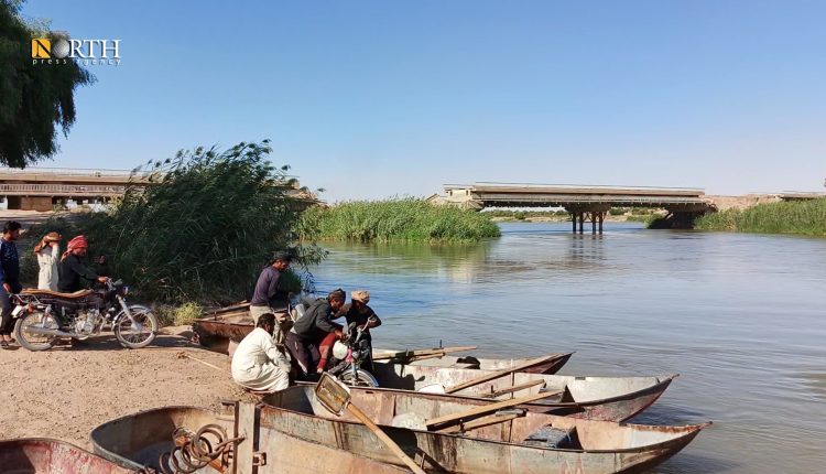 سكان عند جسر العشارة شرقي دير الزور بانتظار العبور للضفة الأخرى من النهر- نورث برس