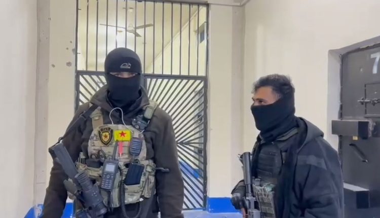 مقاتلان من قسد يحرسان أحد بوابات سجن الأقطان شمال الرقة الذي يضم عناصر من "داعش" - متداول